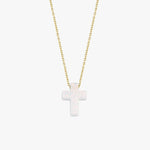 Minimalist studio view of a 14K solid gold necklace with a polished white opal cross pendant, centered on white.