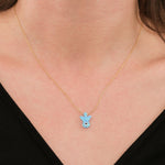 Close-up of a woman wearing a 14K solid gold opal angel necklace with a soft blue opal charm.