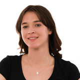 Model smiling while wearing a 14K solid gold opal Hamsa hand necklace styled with a classic black top.