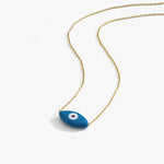 Flat lay image of the 14K solid gold evil eye necklace with a minimalist blue eye pendant on white background.