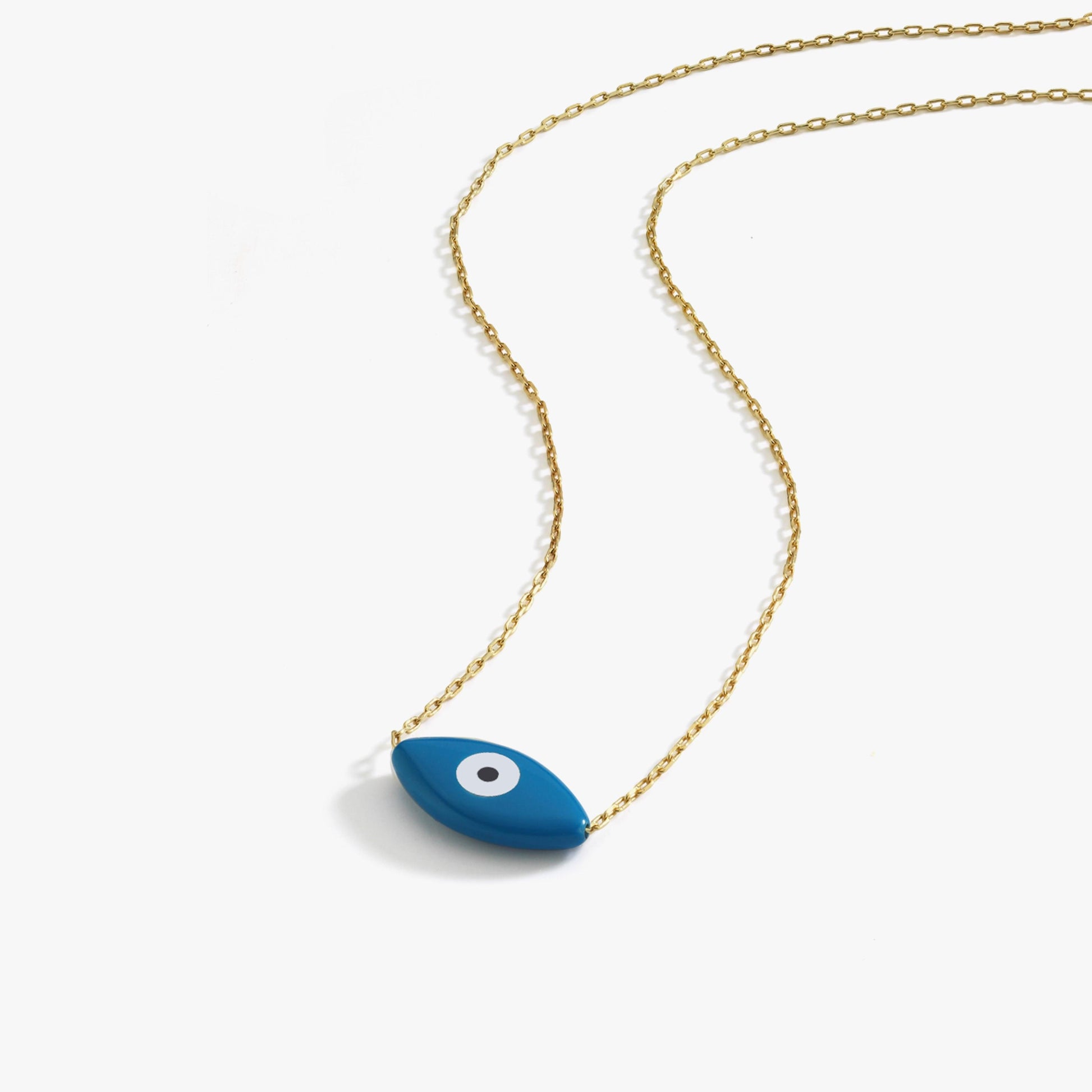 Flat lay image of the 14K solid gold evil eye necklace with a minimalist blue eye pendant on white background.