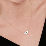 Minimalist image of the 14K solid gold white opal necklace resting on the collarbone, reflecting a soft pearly shine.