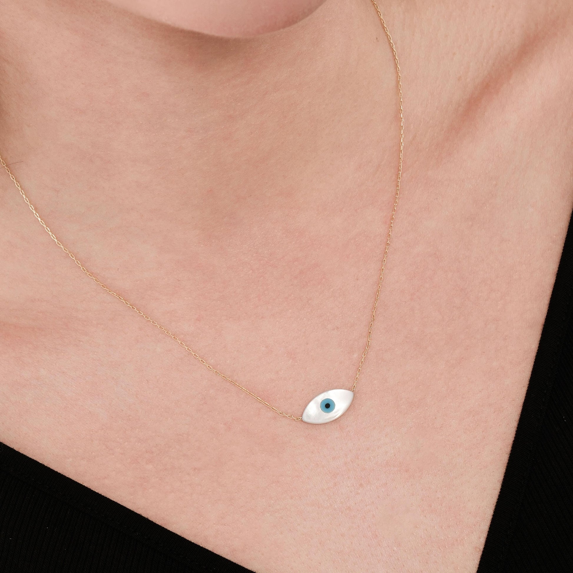 Minimalist image of the 14K solid gold white opal necklace resting on the collarbone, reflecting a soft pearly shine.