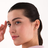 Woman with dark hair pulled back, wearing a 14K solid gold moth earring on her right ear.