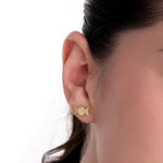 14K solid gold triple moon earrings styled on a model's ear against a white background, showcasing their symbolic and subtle elegance.