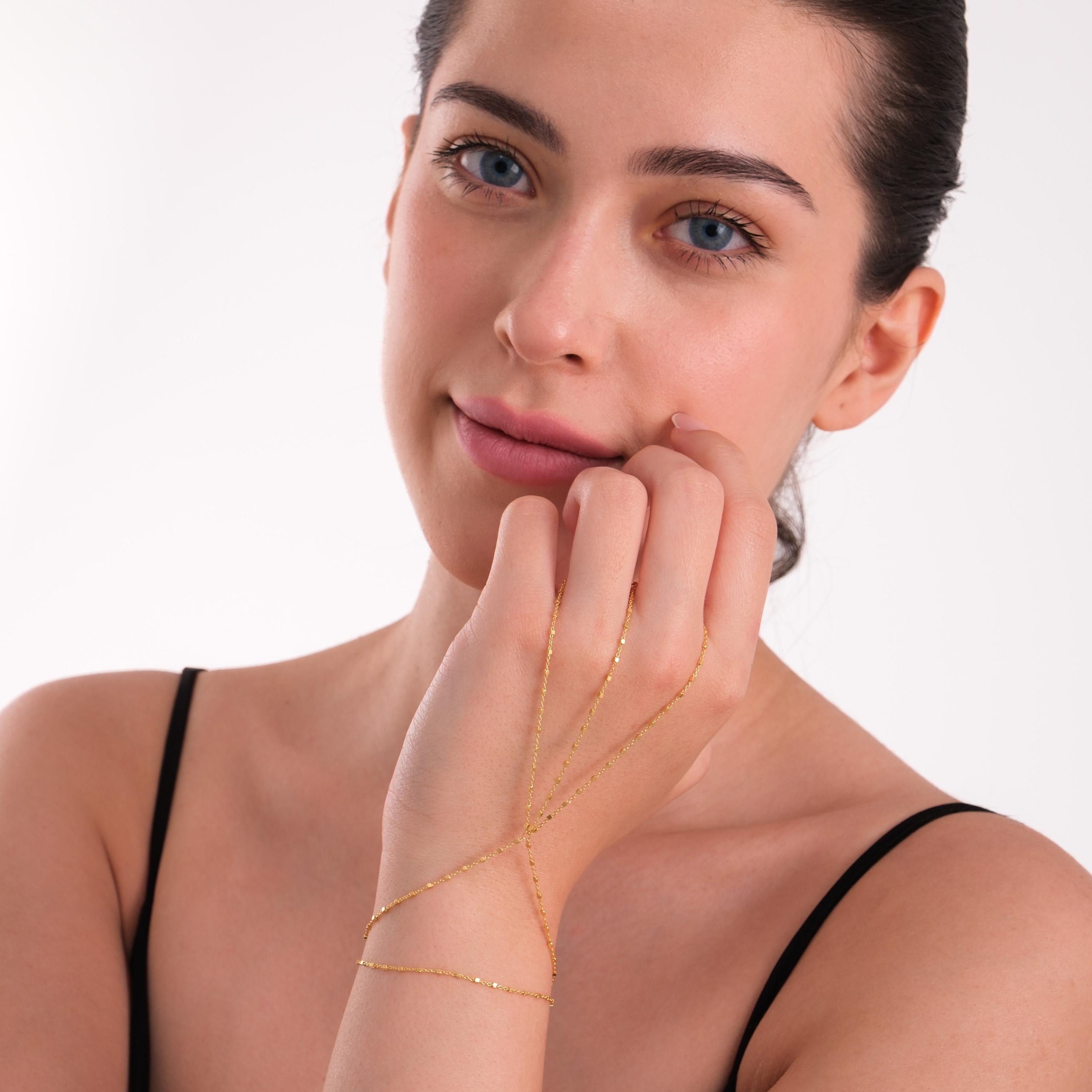 Model softly touching her face, wearing the 18K gold vermeil hand chain, which creates a graceful silhouette across her hand.
