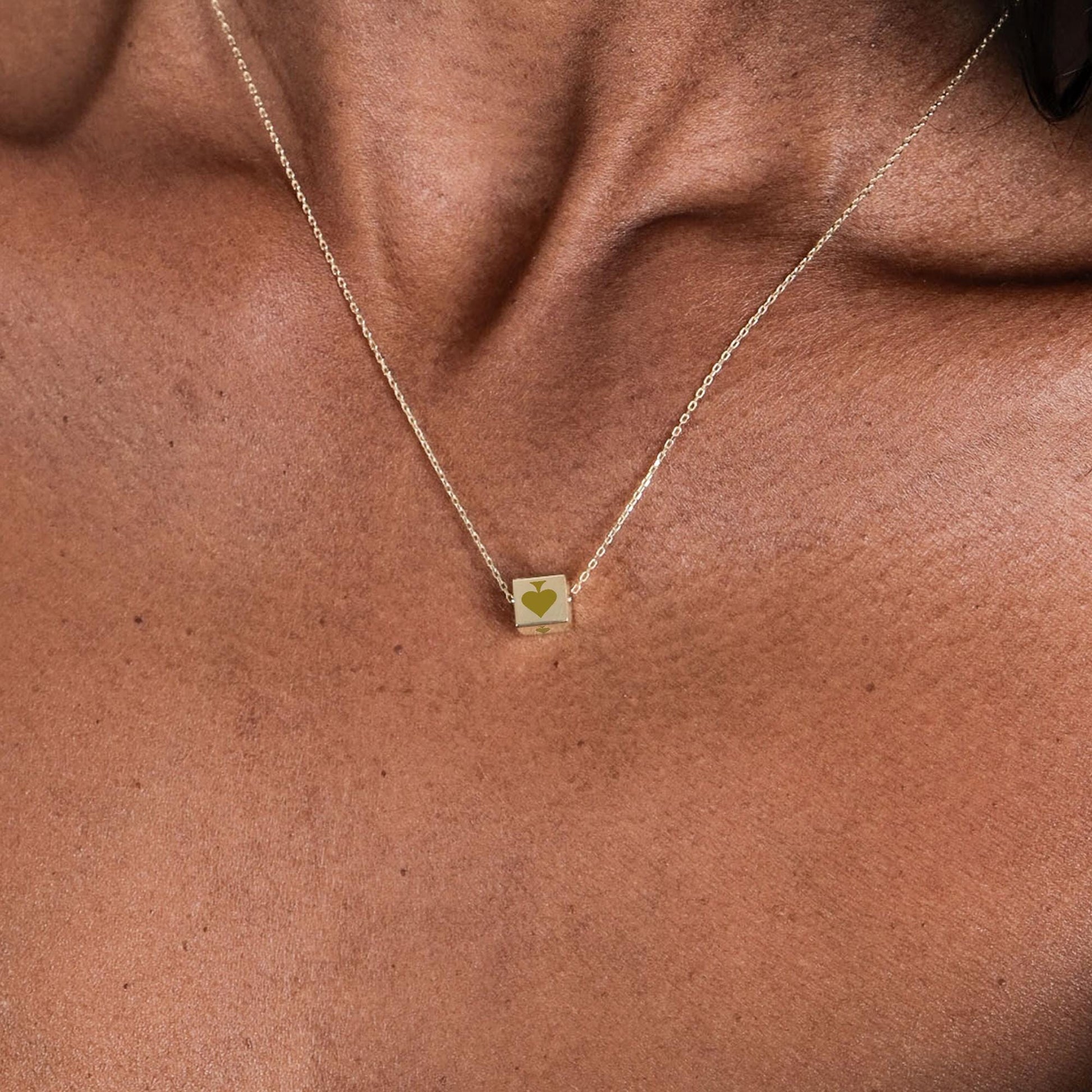 Close-up view of a 14K solid gold Spade Cards necklace