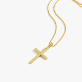 The 18K Gold Vermeil Cross Necklace with a diamond accent shown on a flat surface.