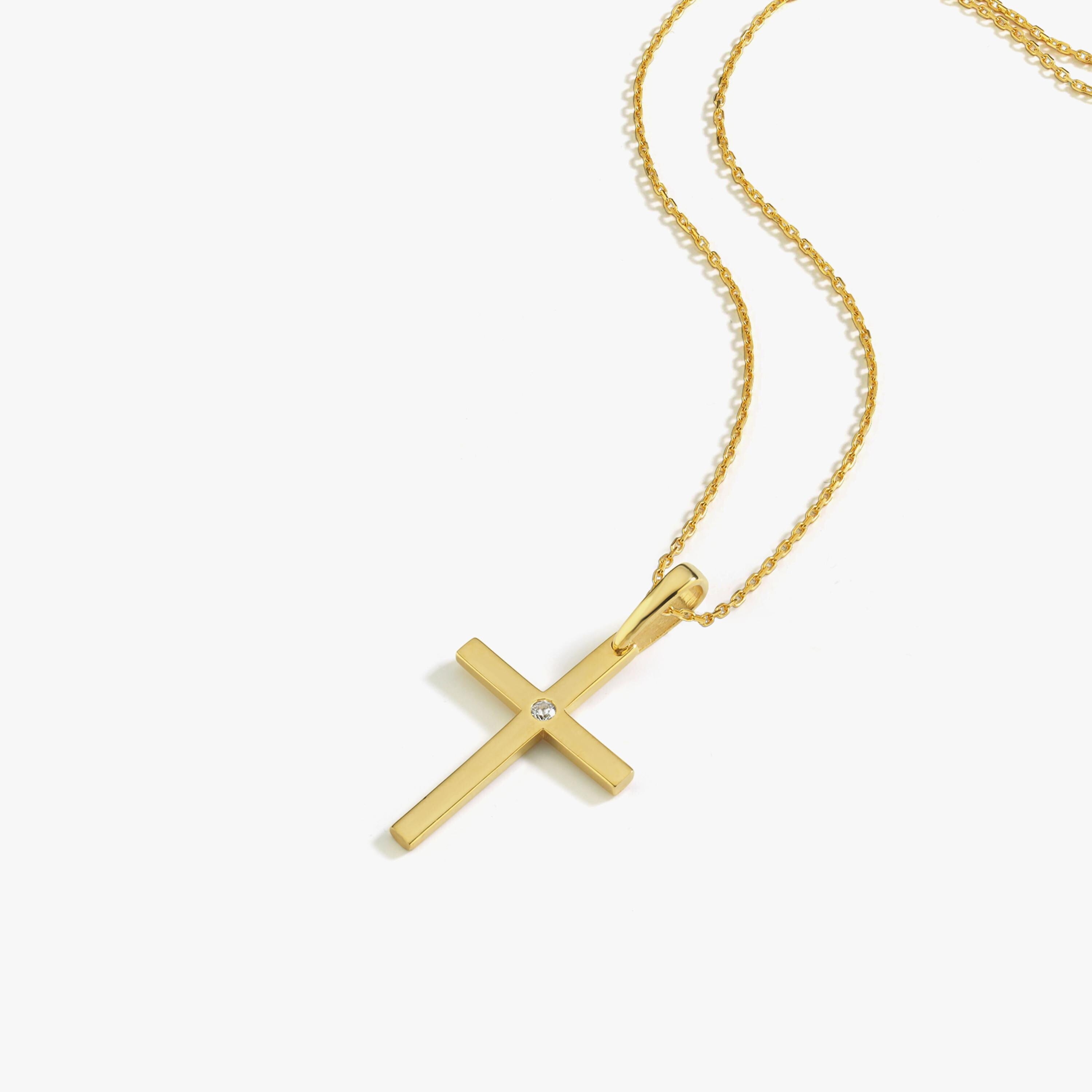 The 18K Gold Vermeil Cross Necklace with a diamond accent shown on a flat surface.