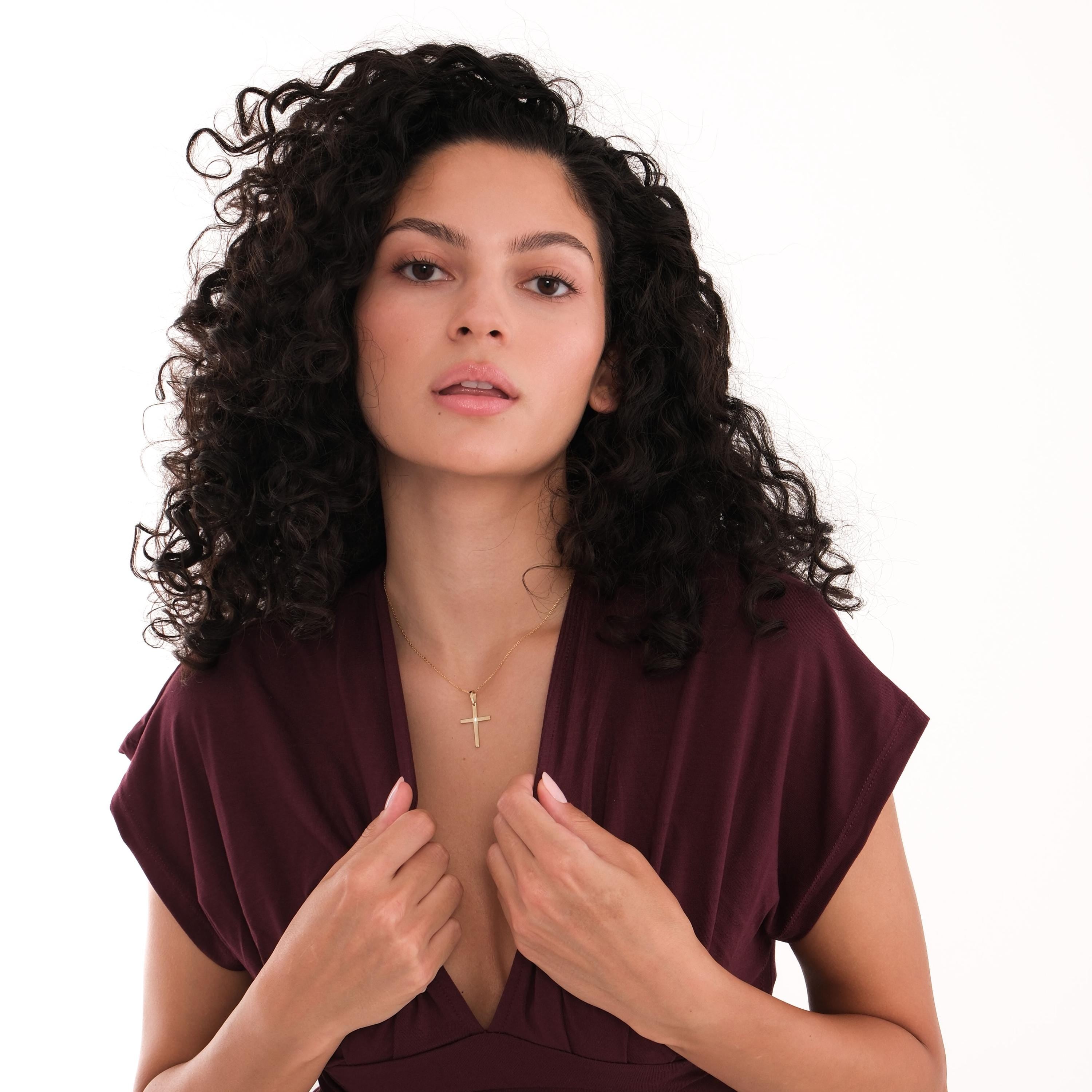 Full view of a woman wearing the 18K Gold Vermeil Cross Necklace, looking at the camera.