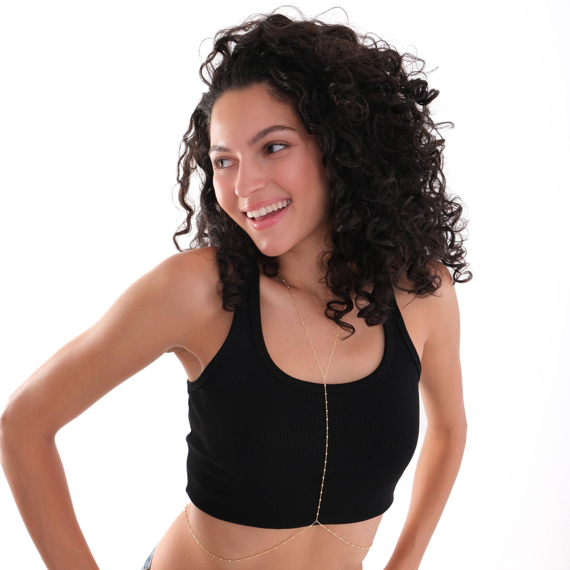 Model in a relaxed pose wearing the 18K Gold Vermeil Beaded Body Chain draped over her body.