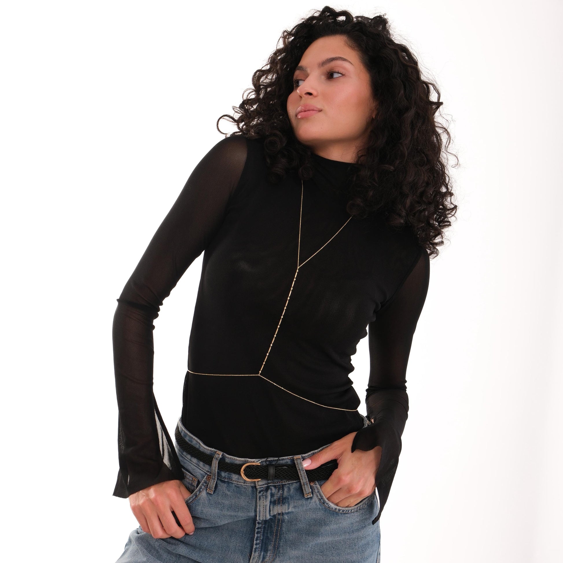 Model poses with 18K Gold Vermeil Bar and Bead Body Jewelry worn over a sheer long-sleeve black top.