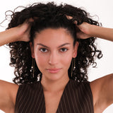 A woman with curly hair wears 14K Solid Gold Threader Earrings with Real Pearl.