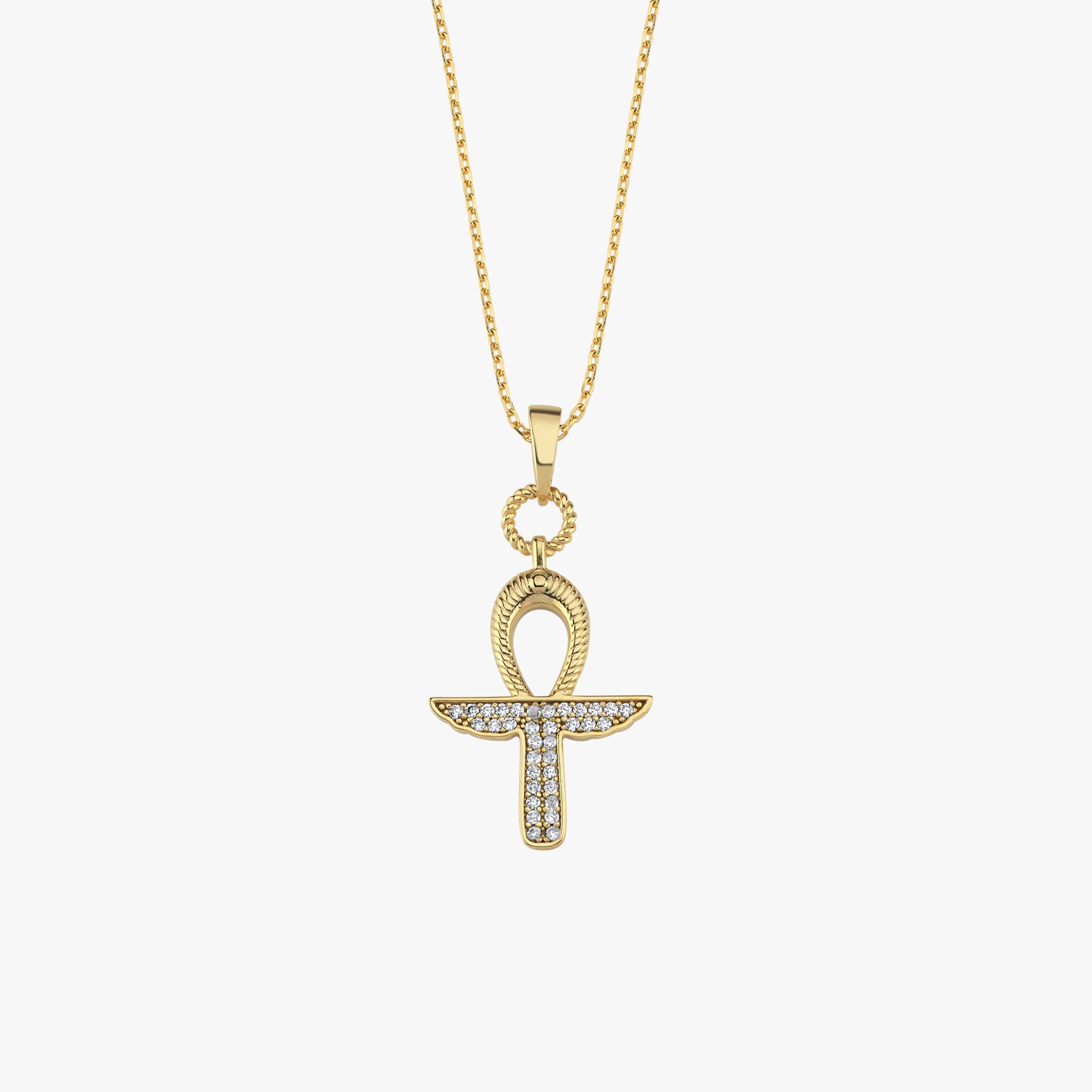 The model’s hand draws attention to the sparkling 18K Gold Vermeil Ankh Necklace on her neckline.