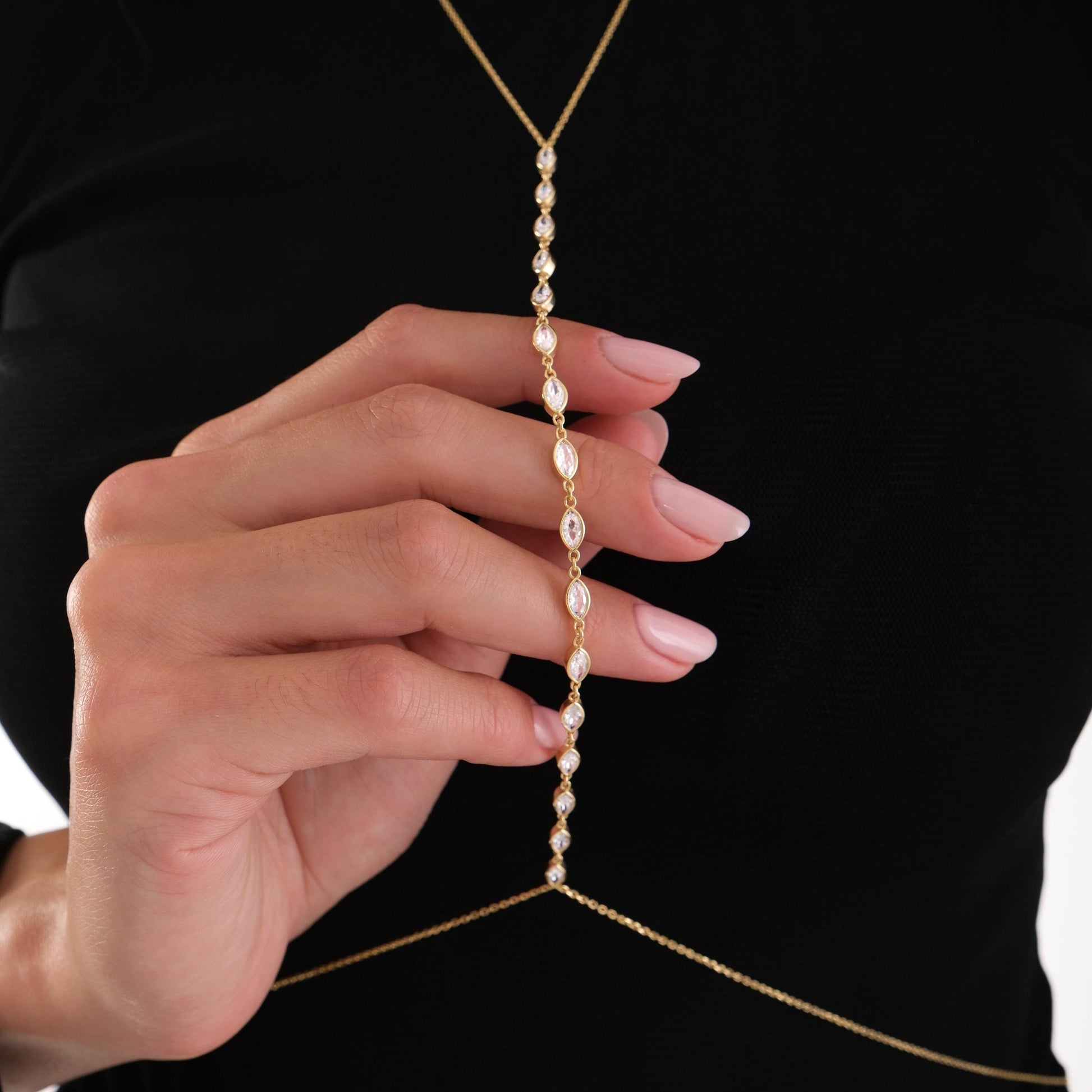 Close-up of the model holding the chain, showing the fine stones and gold finish of the 18K Gold Vermeil Body Chain Jewelry.