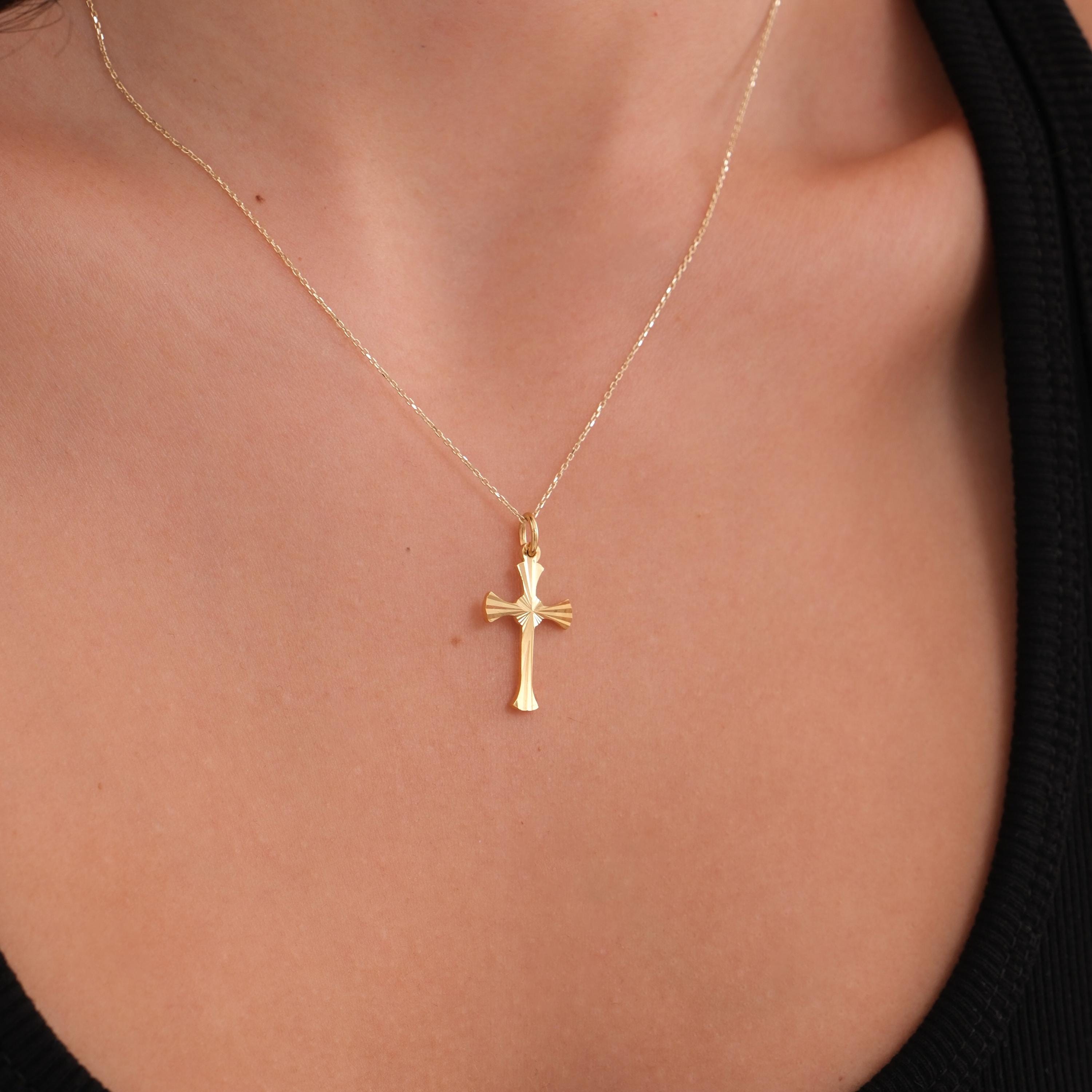 The 18K Gold Vermeil Cross Necklace rests elegantly on the model’s neckline with a fine chain.