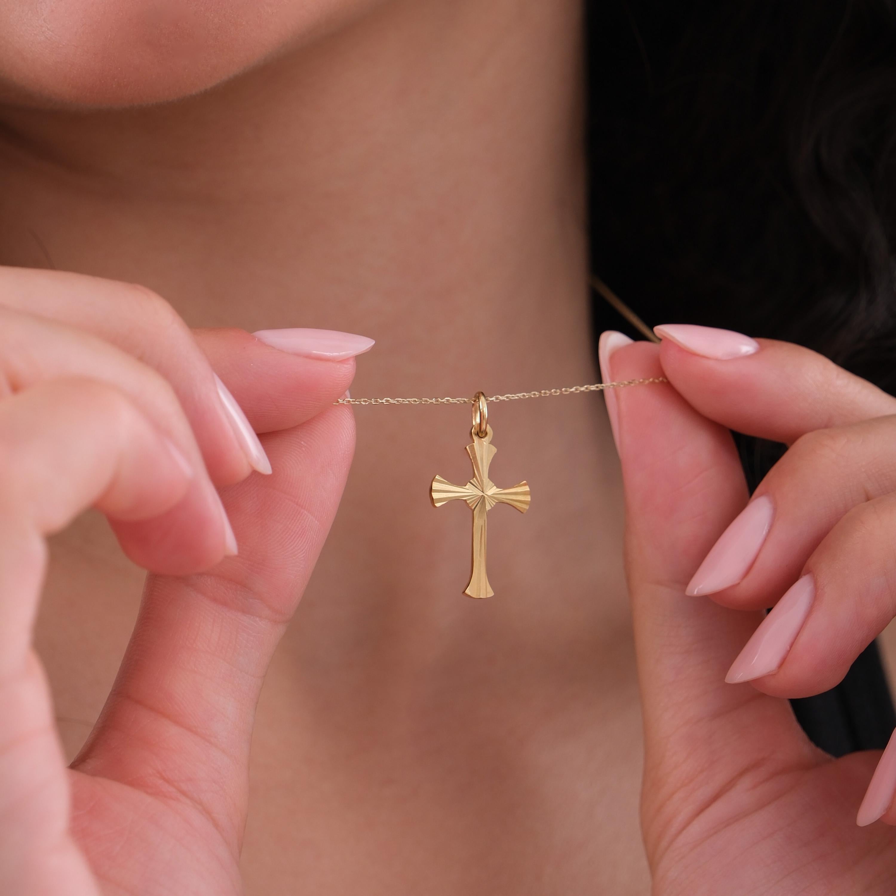Model holds the chain to display the intricate cross pendant of the 18K Gold Vermeil Cross Necklace.