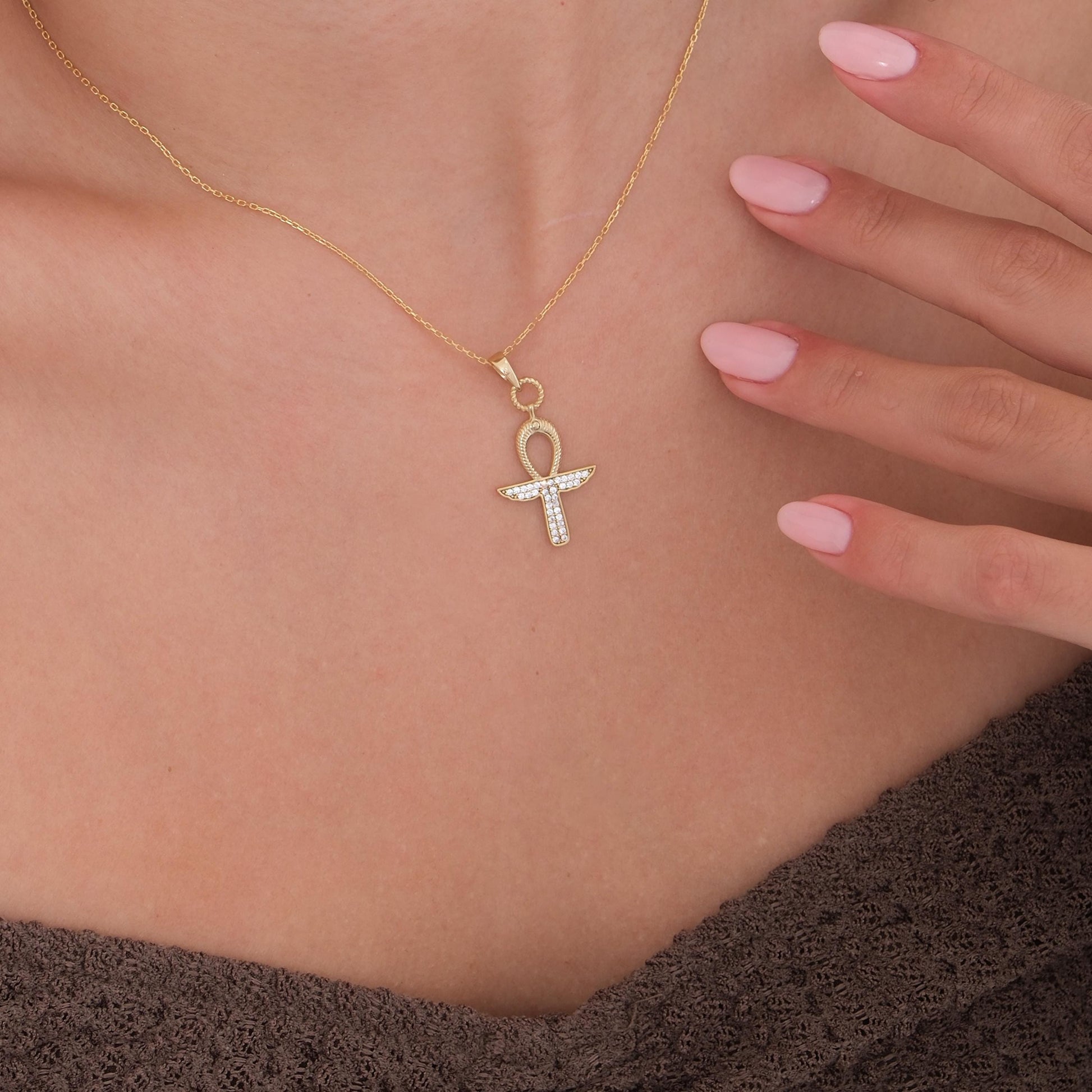 The 18K Gold Vermeil Ankh Necklace is shown from an angle, emphasizing the textured detailing and shine.