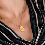 Front-facing view of an 18K gold vermeil handwriting necklace with a child’s drawing and “I love you” message engraved on a shiny rectangular pendant.