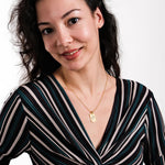 Custom gold pendant necklace made of 18K gold vermeil, engraved with a child's handwritten illustration and “I love you” message, styled on the collarbone.