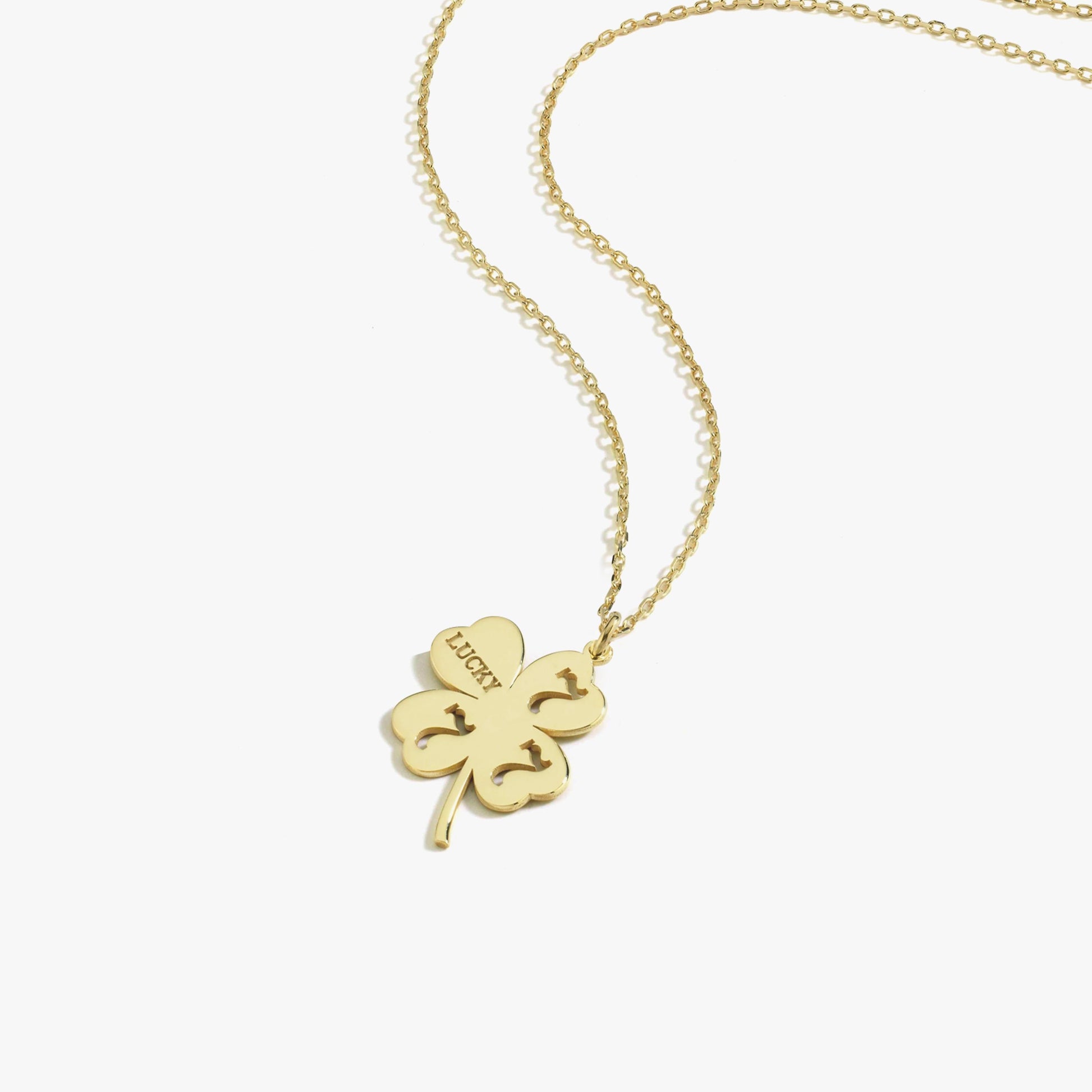 Close-up of the four-leaf clover pendant in solid 14K gold, a symbol of good luck.