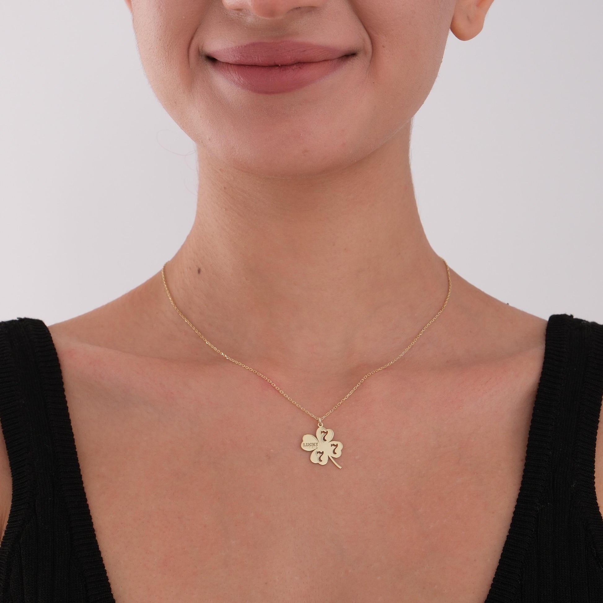 Model wearing dainty four-leaf clover charm necklace, radiating elegance.
