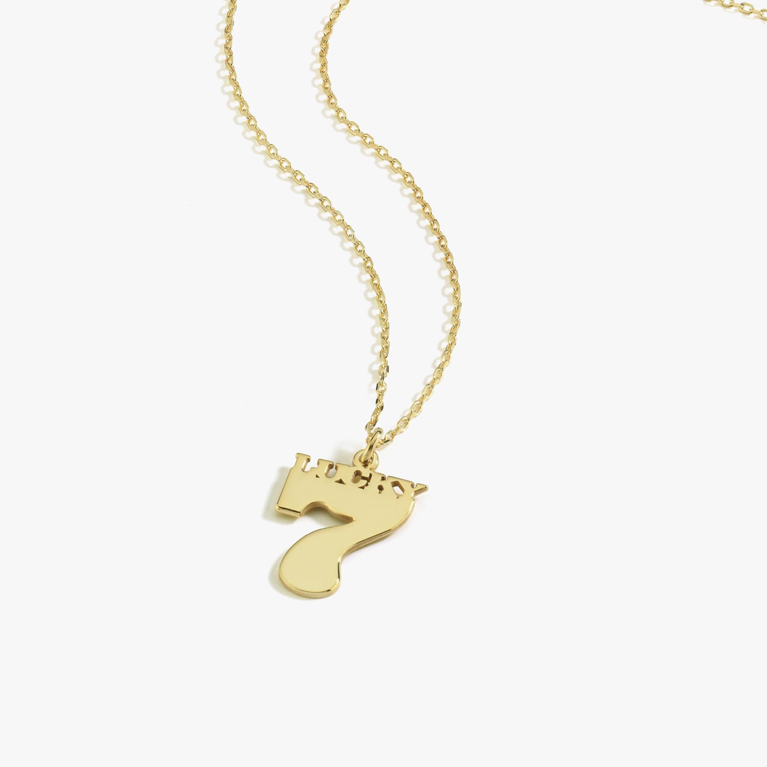 Studio shot of the Lucky Seven gold necklace with a bold number 7 pendant and polished finish.