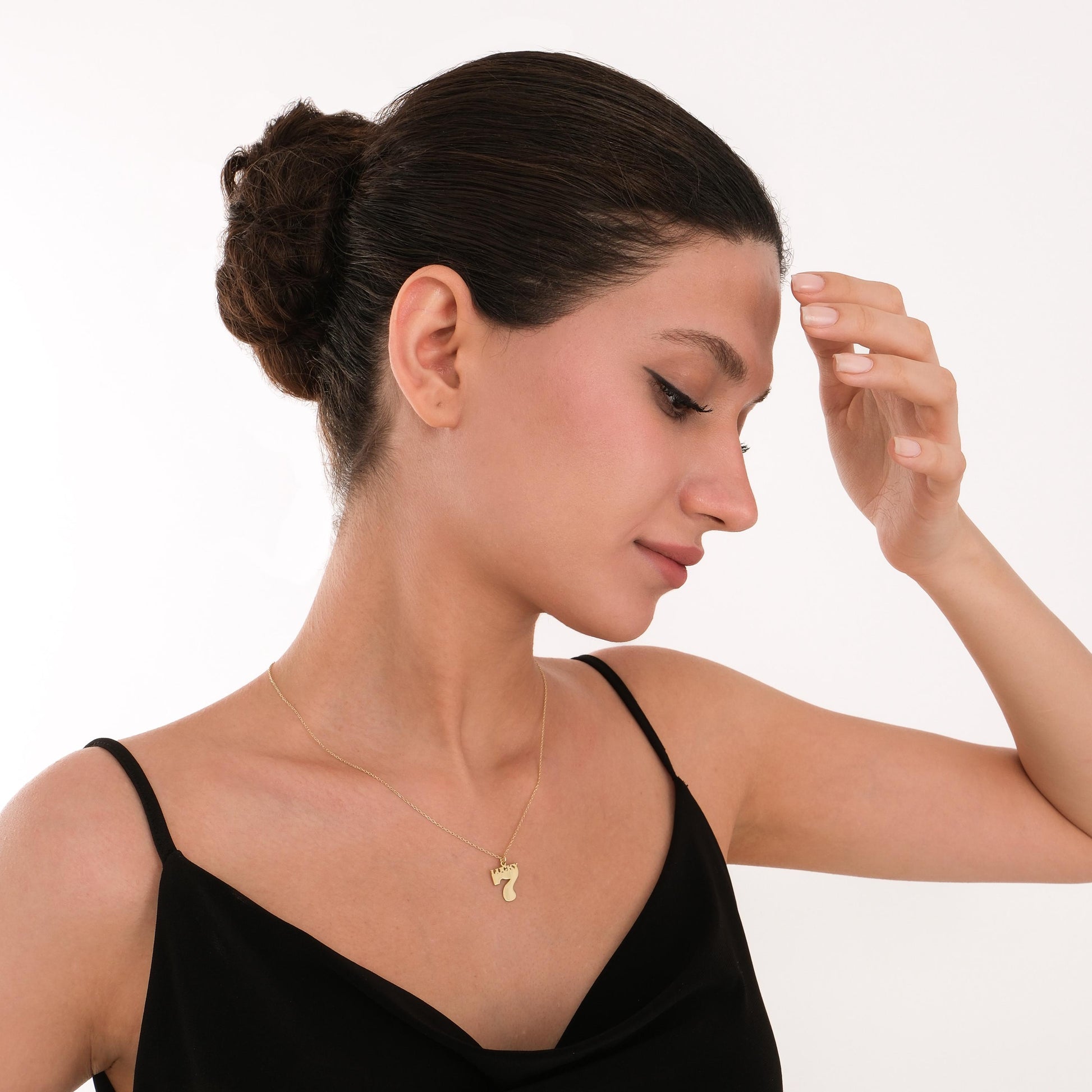 Stylish 14K gold number 7 necklace paired with a black outfit for a modern, lucky look.