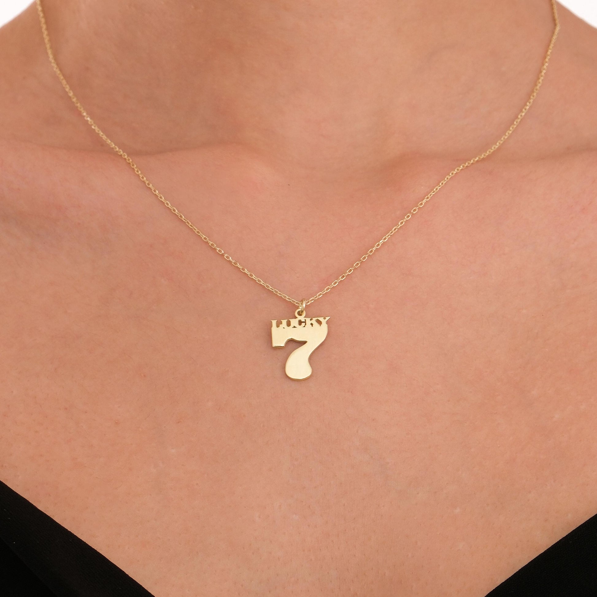 Close-up view of the 14K solid gold Lucky 7 necklace resting elegantly on the collarbone.