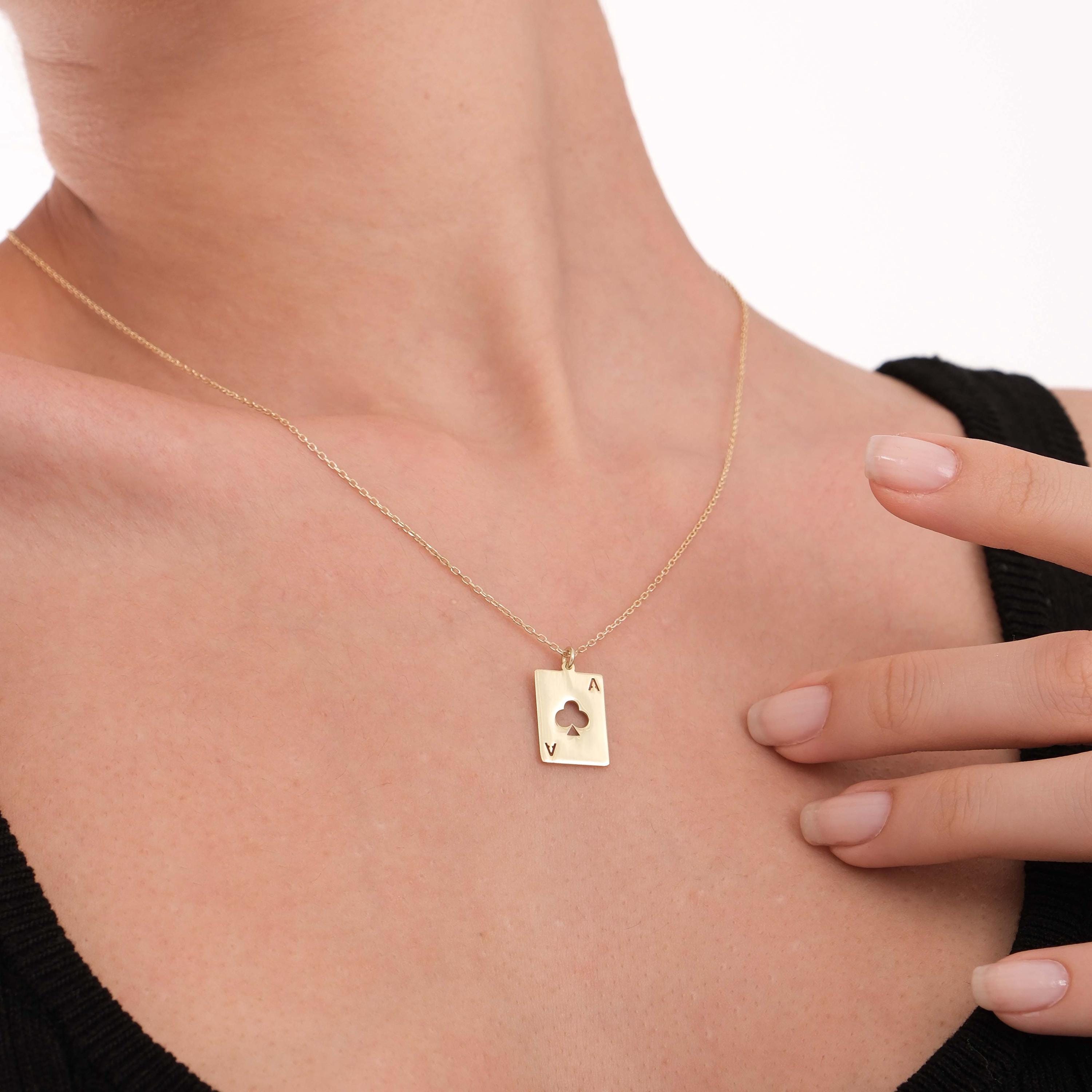 Close-up of the 14K Solid Gold Playing Card Necklace resting on the model’s.