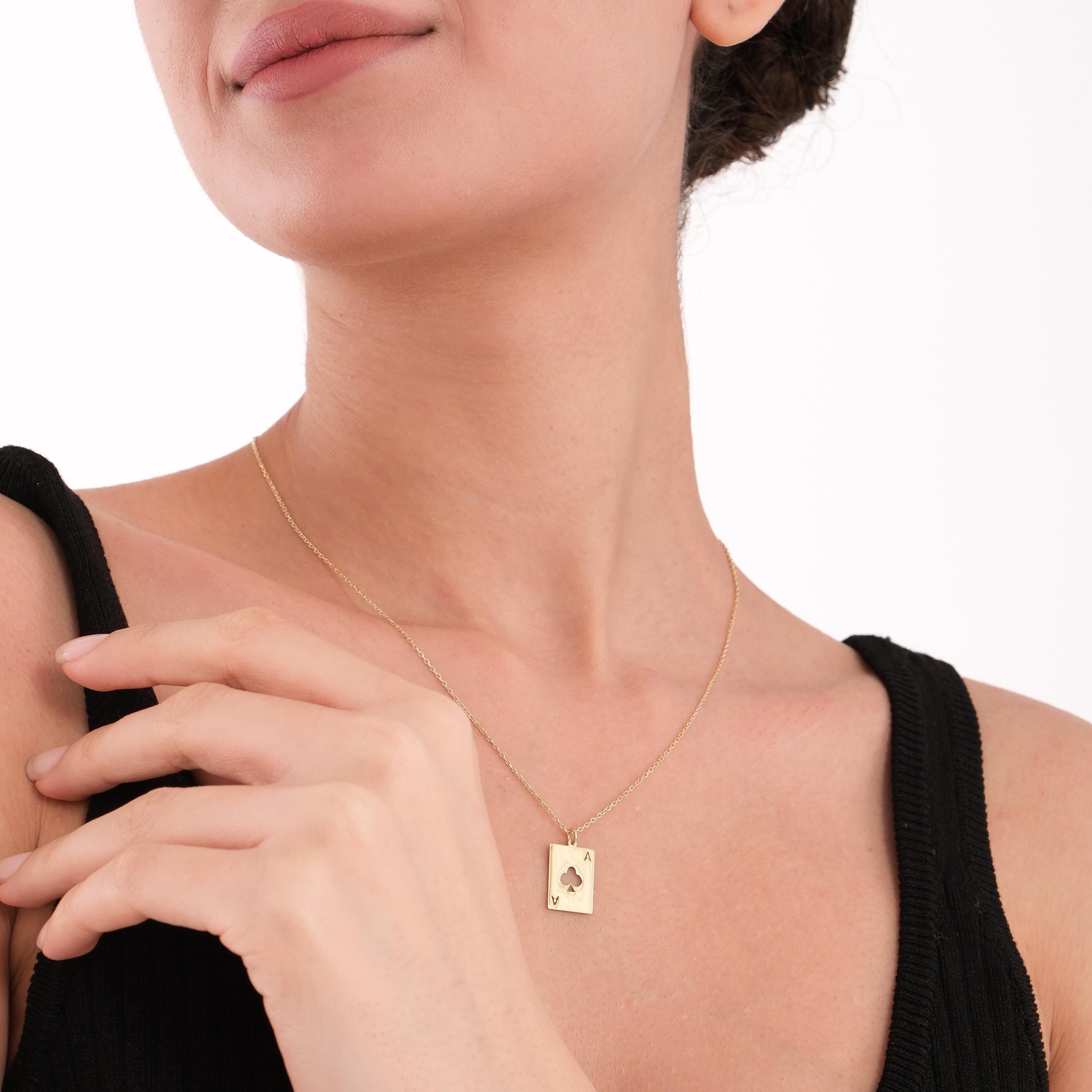 Woman posing with a soft smile while wearing a 14K Solid Gold Playing Card Necklace.
