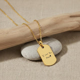 Personalized 18K gold vermeil handwriting necklace with “I love you Mom ♥” engraving on a gold dog tag pendant, styled on a stone and wooden background.