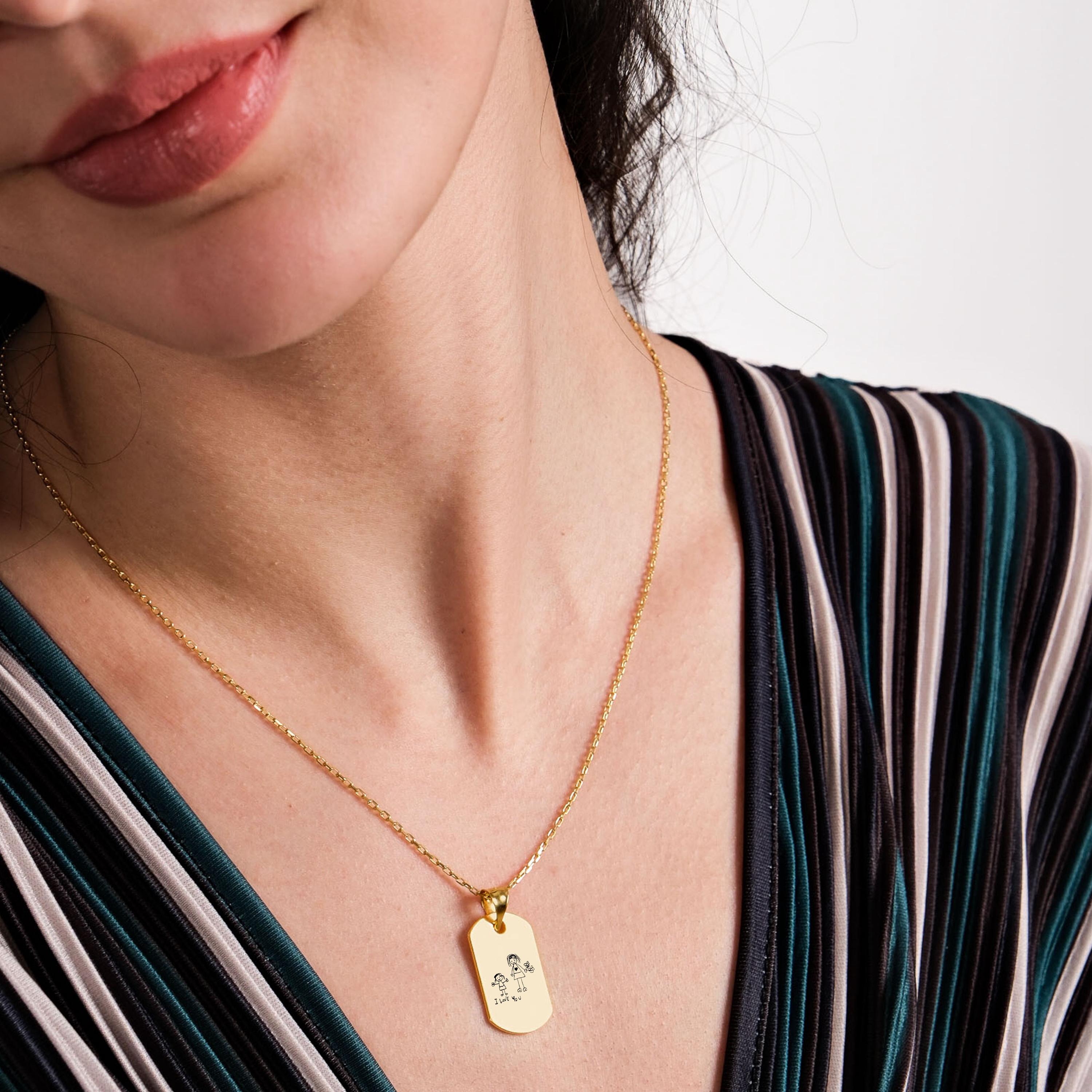 Close-up of an 18K gold vermeil handwriting necklace worn by a smiling woman, featuring a personalized child’s drawing and heartfelt message.
