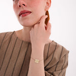 The 14K solid gold Kids Handwriting Bracelet subtly shines on the wrist in a soft portrait.