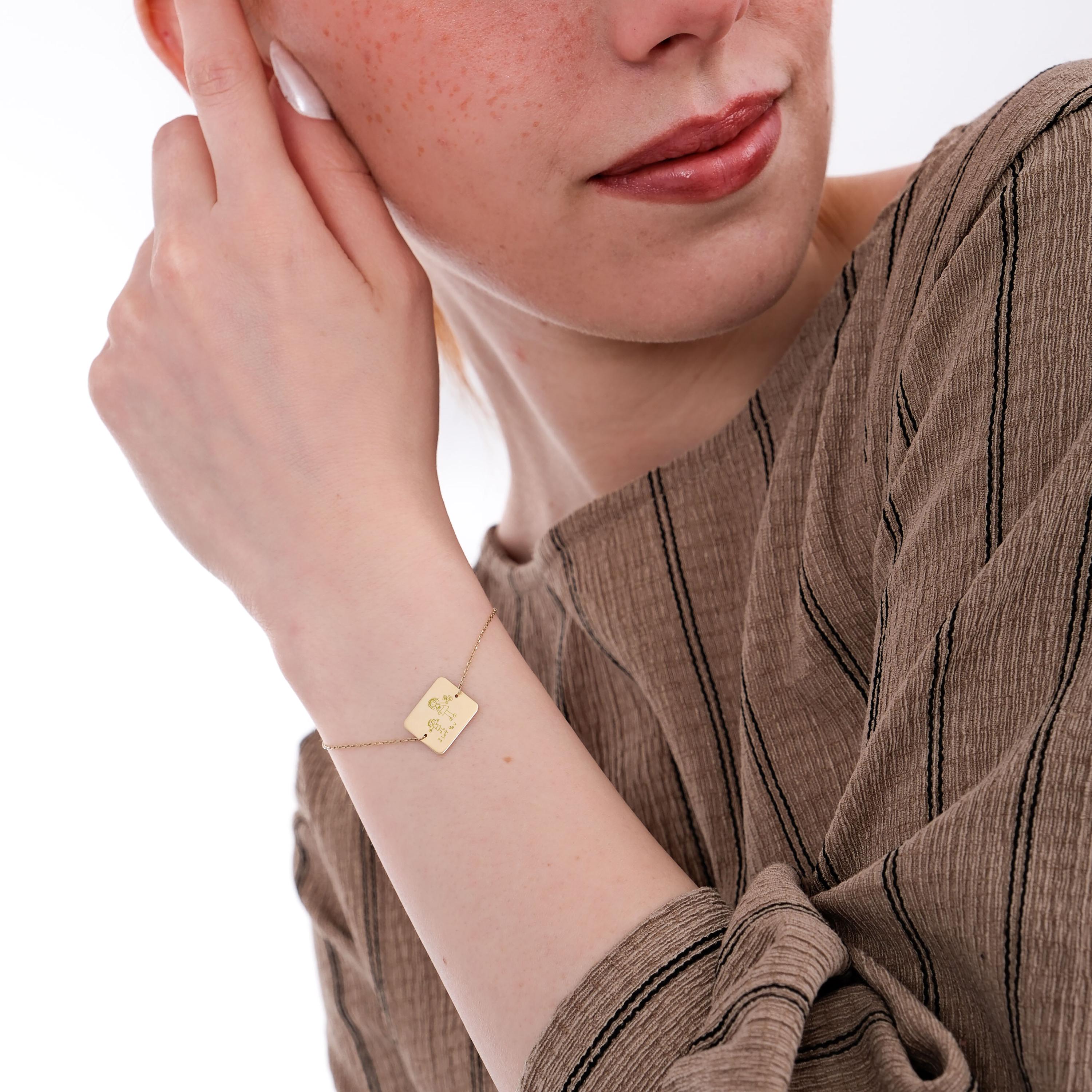 14K solid gold Kids Handwriting Bracelet seen clearly as the model touches her face.