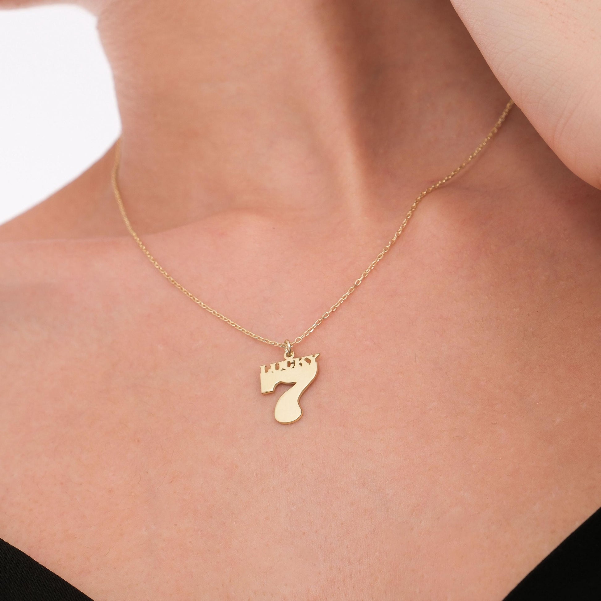 The gold Lucky Seven pendant catches the light beautifully against the skin.