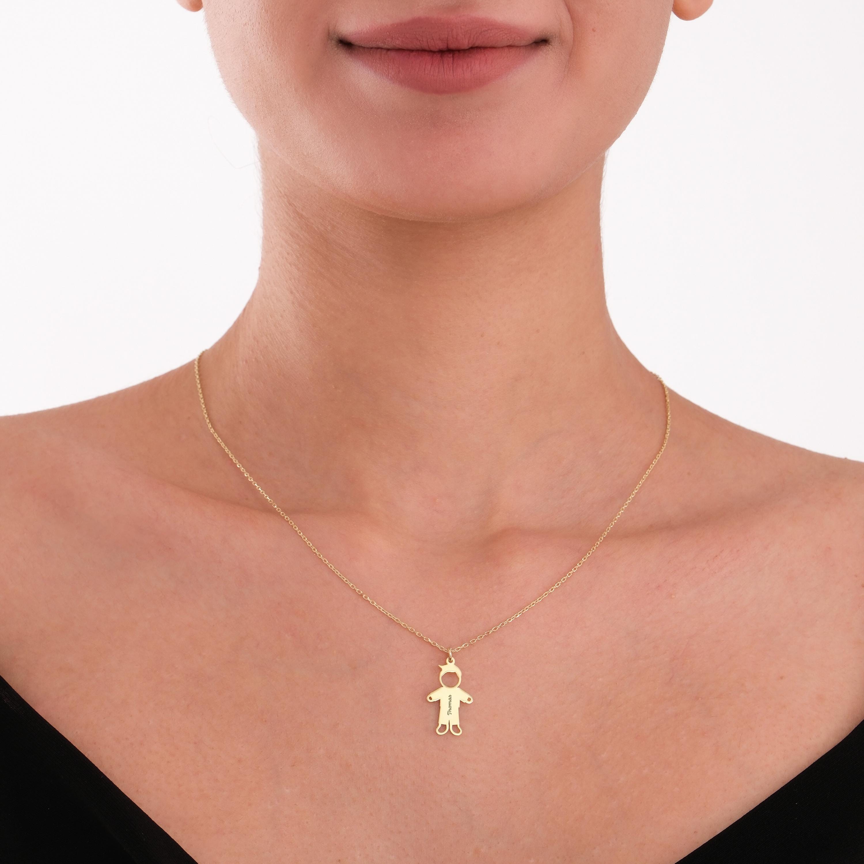 Centered on the chest, this personalized family necklace features a minimal gold boy figure.