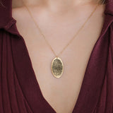 14K solid gold fingerprint necklace with an oval pendant, worn with a burgundy V-neck top.