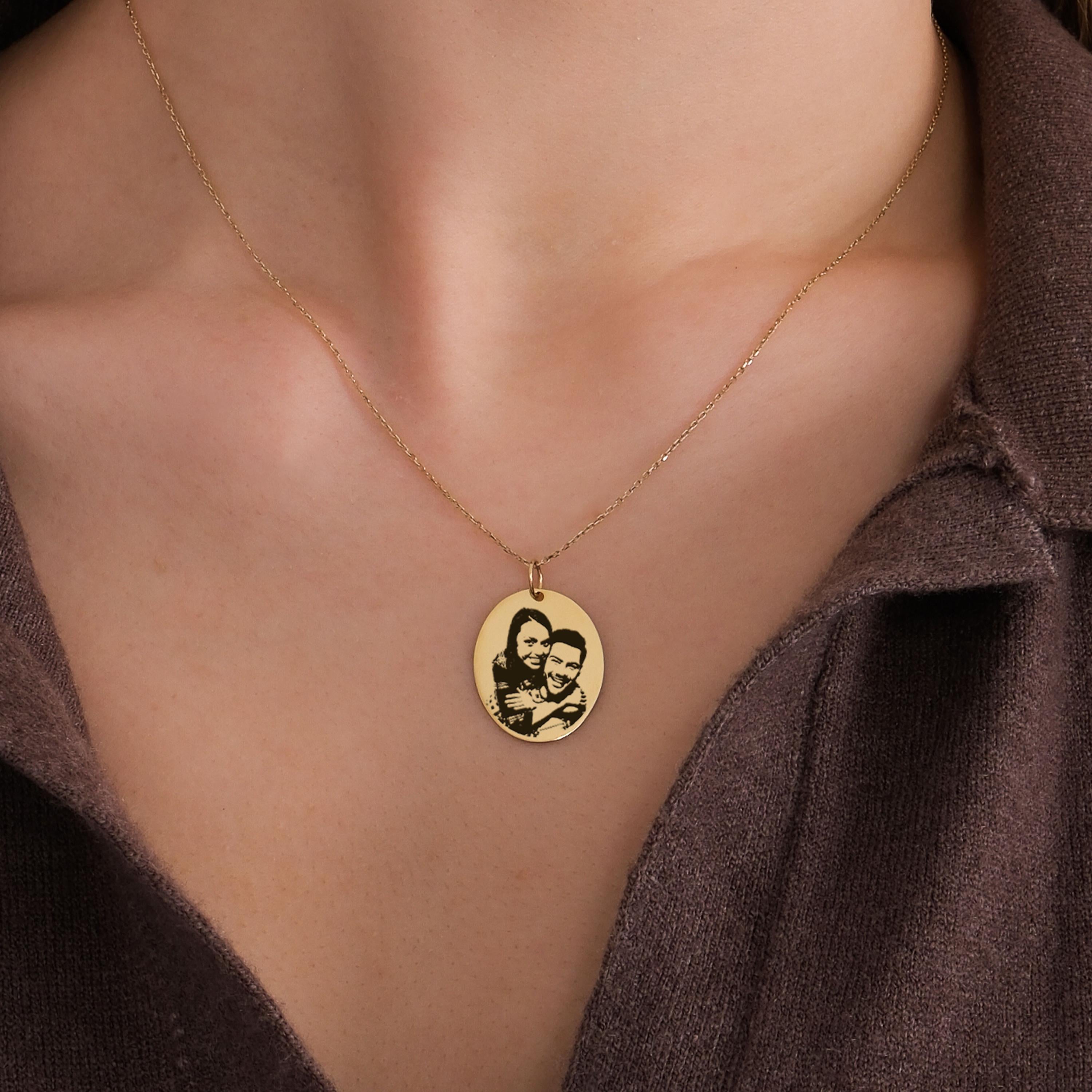 14K solid gold engraving photo necklace shown close-up on a woman’s neck, displaying a custom portrait of a couple.