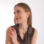 Woman wearing a 14K solid gold engraving photo necklace with a custom couple portrait, captured in a soft profile view.