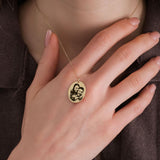 Close-up of a woman's hand gently touching a 14K solid gold engraving photo necklace featuring a custom image of a smiling couple.