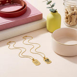Two 18K Gold Vermeil Pet Photo Necklace pendants featuring a custom pet portrait and engraved message, displayed on a neutral surface.