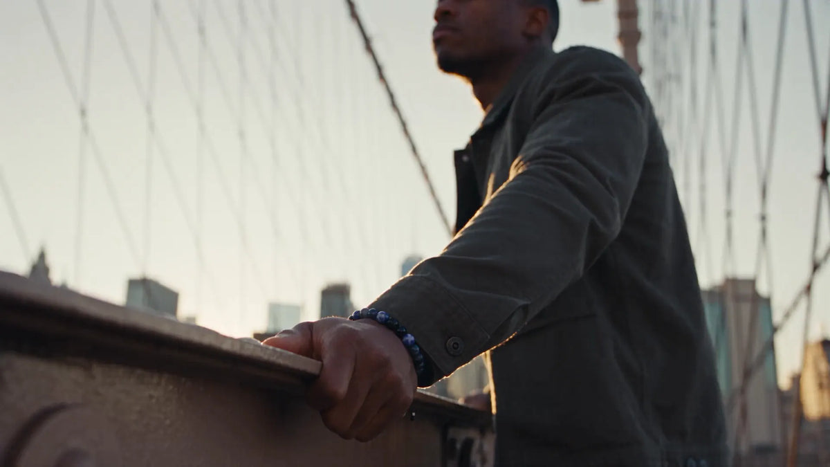 Man on the Brooklyn Bridge at sunrise wearing a sodalite bead bracelet