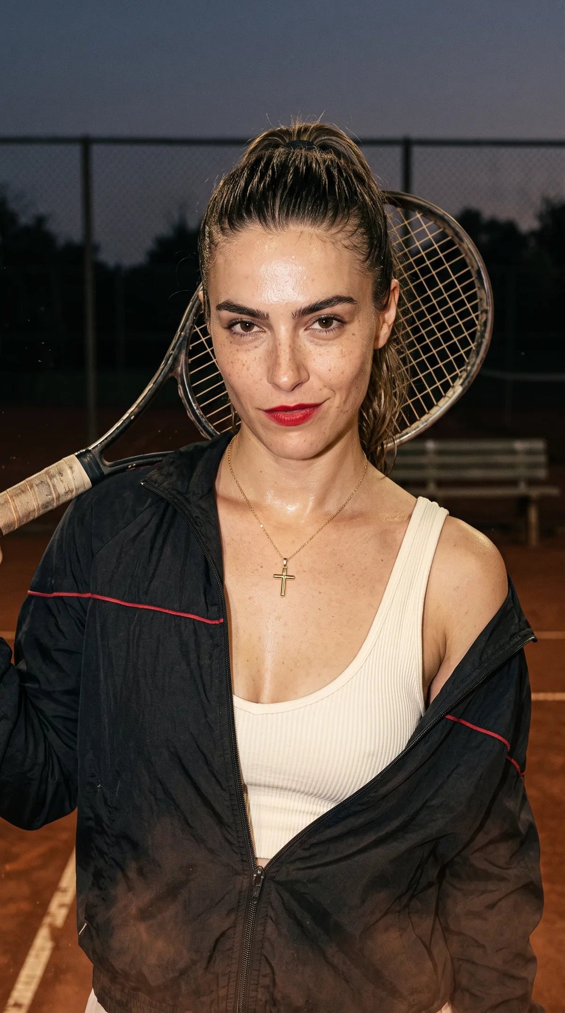 Classic cross necklace worn on a tennis court