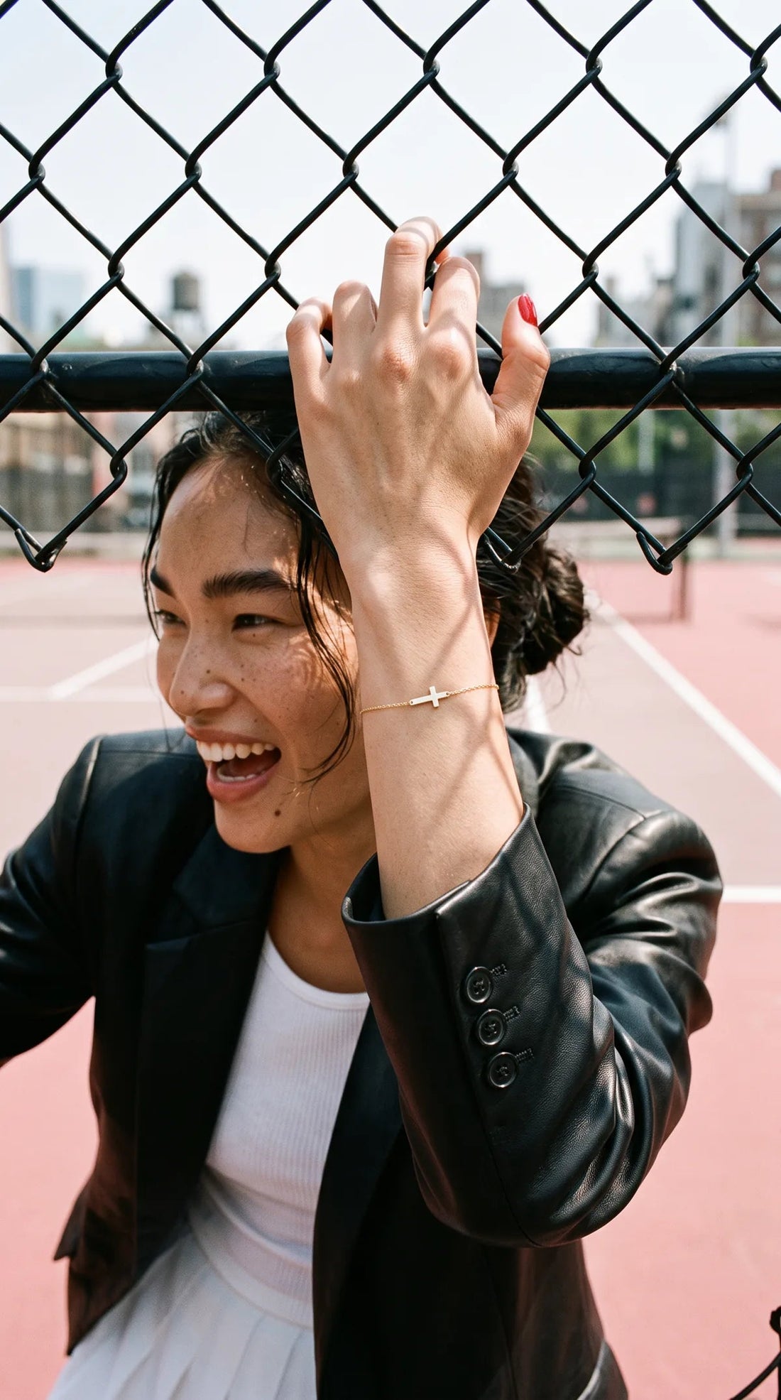 Gold cross bracelet worn on the wrist
