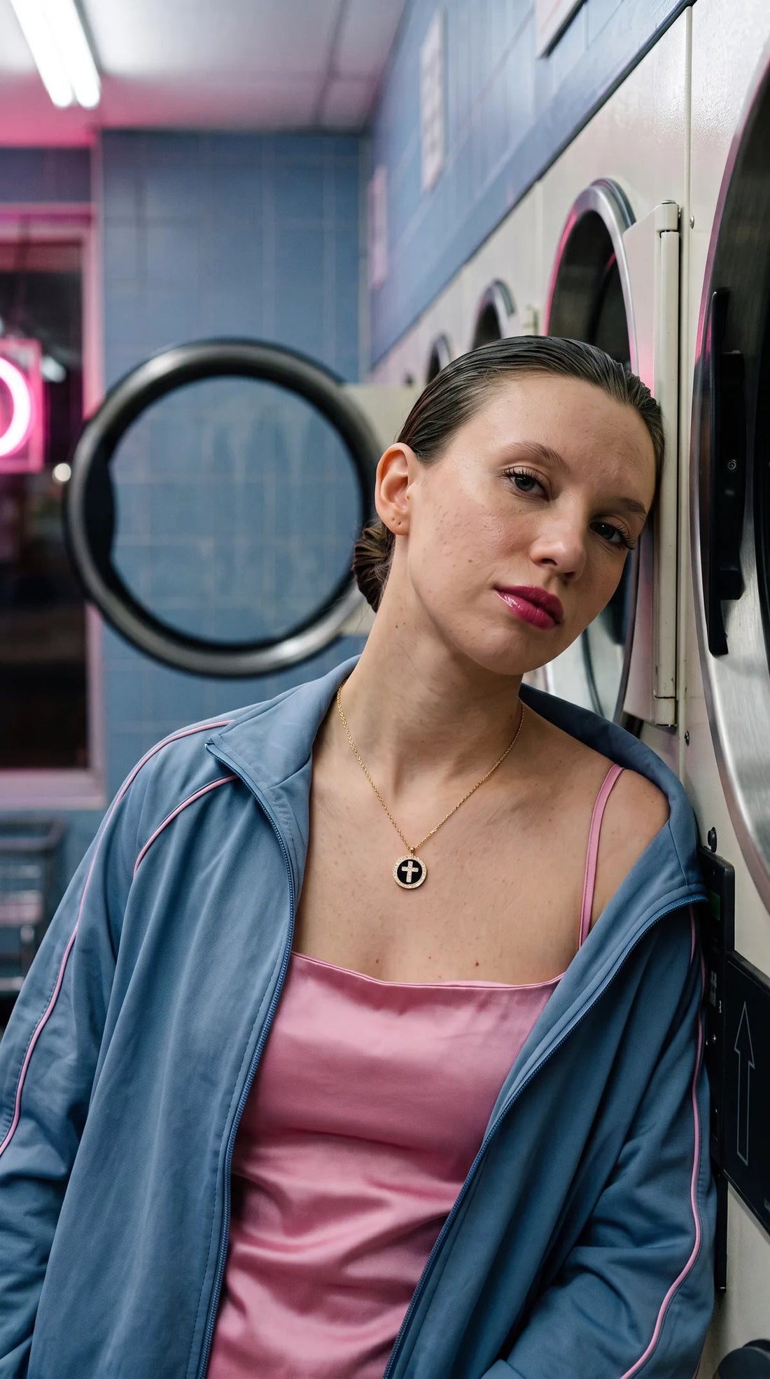 Cross coin necklace worn in a laundromat