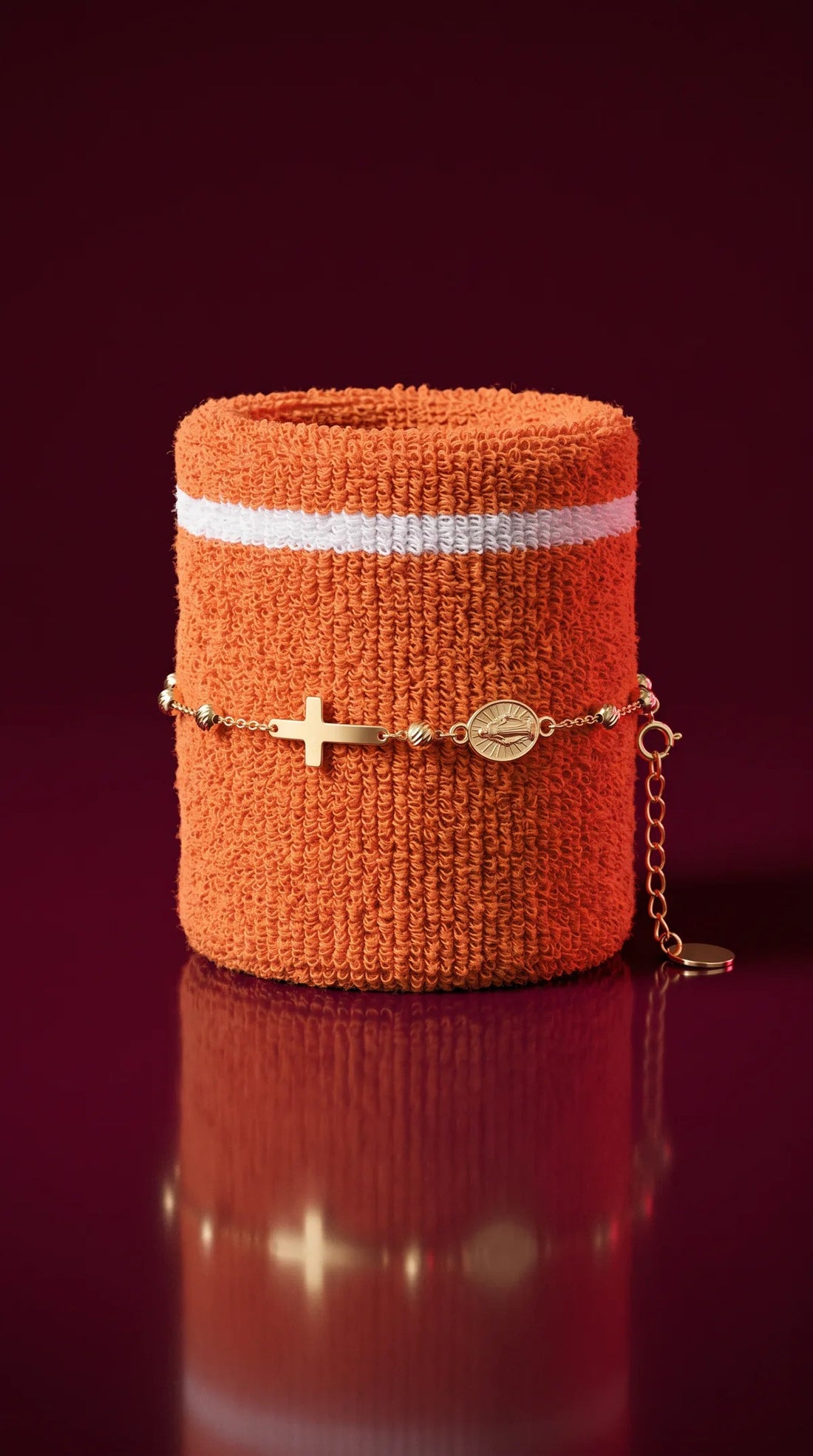 Gold rosary bracelet on an orange sweatband