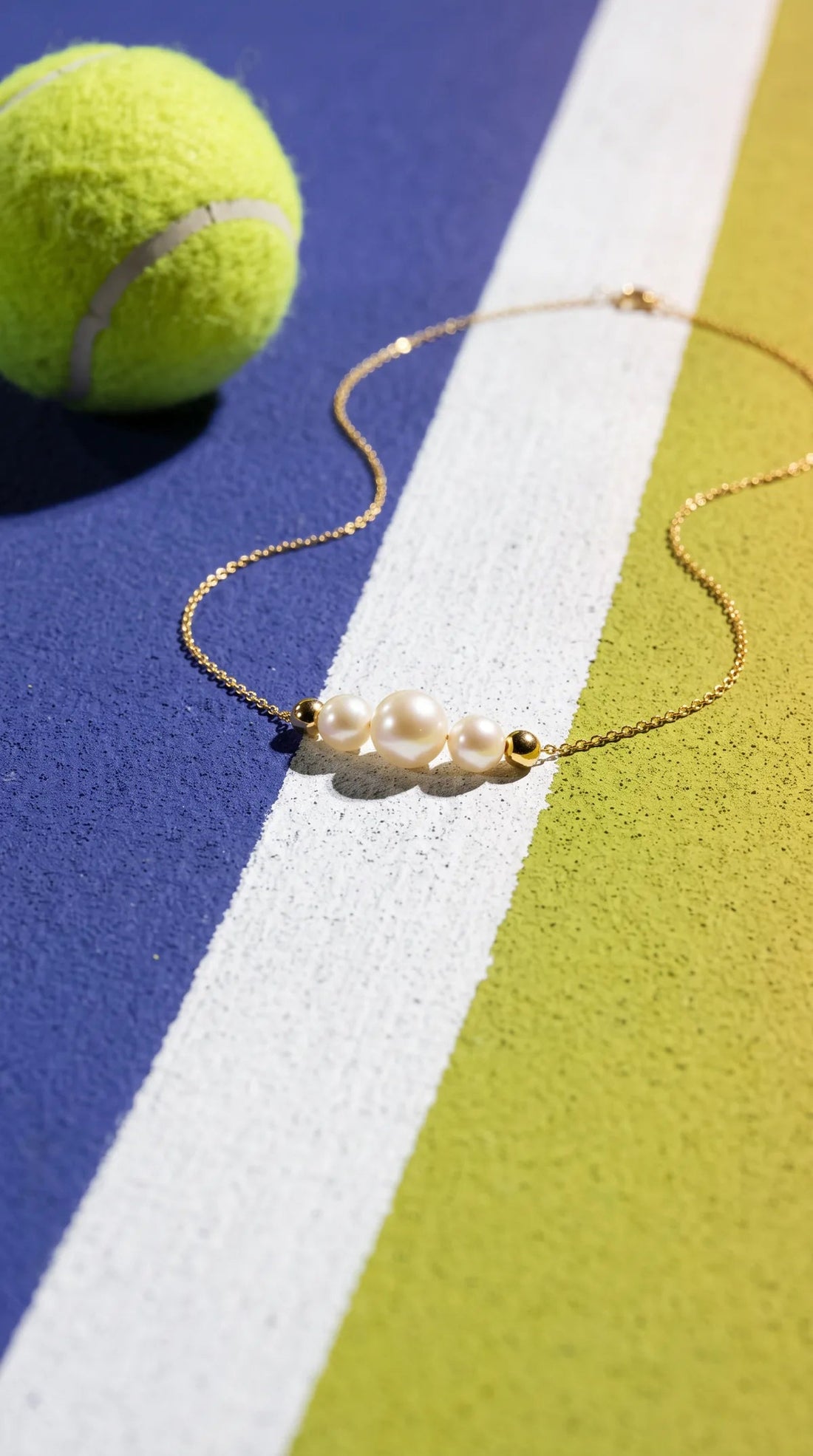 Triple pearl necklace on a tennis court line