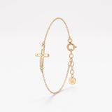 Gold sideways cross bracelet for women, an open cross with a single sparkling center stone on a dainty chain with extender