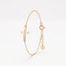 Gold sideways cross bracelet for women, an open cross with a single sparkling center stone on a dainty chain with extender